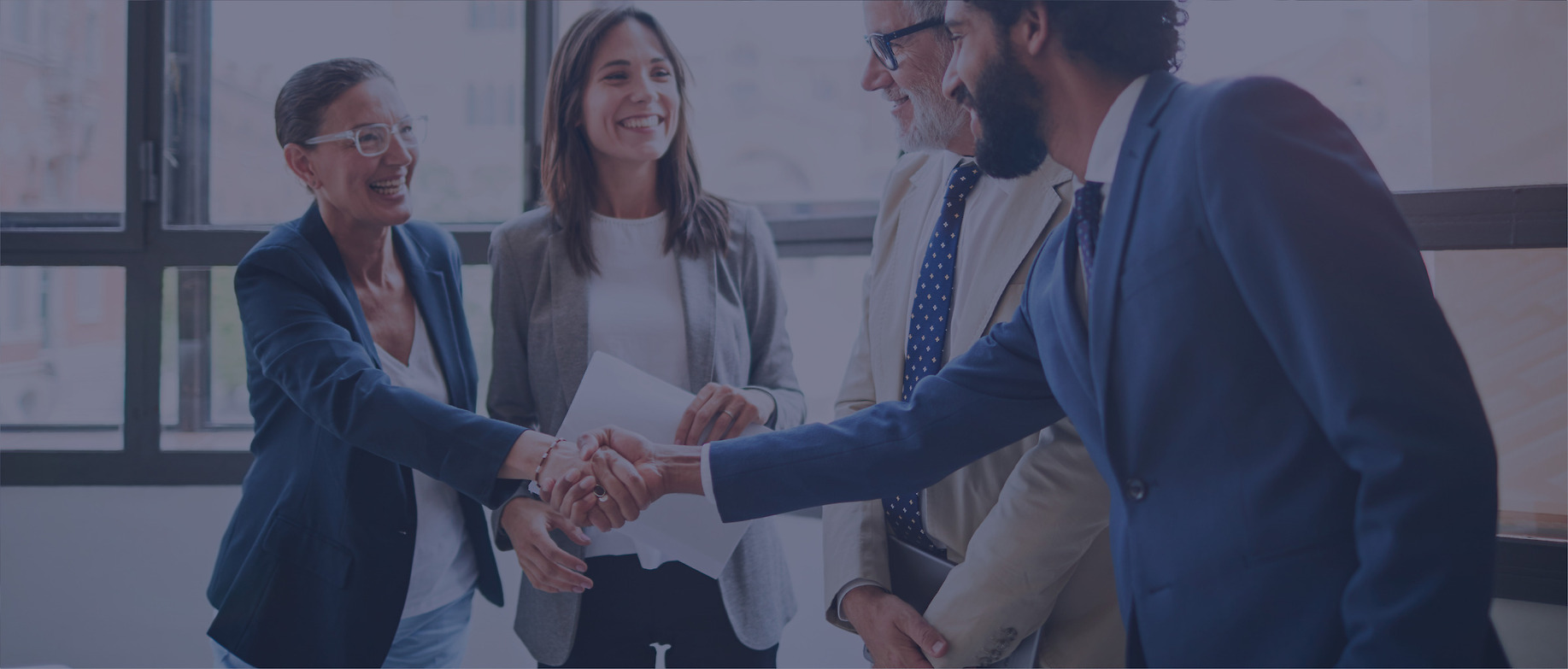 Group of people shaking hands and smiling.