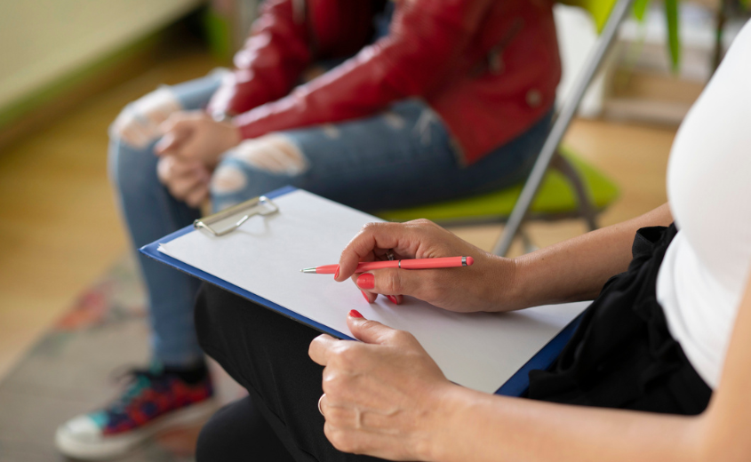 Person writing on a clip board