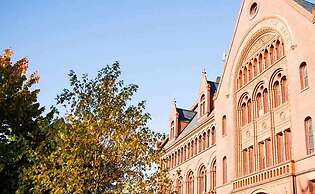 Red brick college building with trees next to it